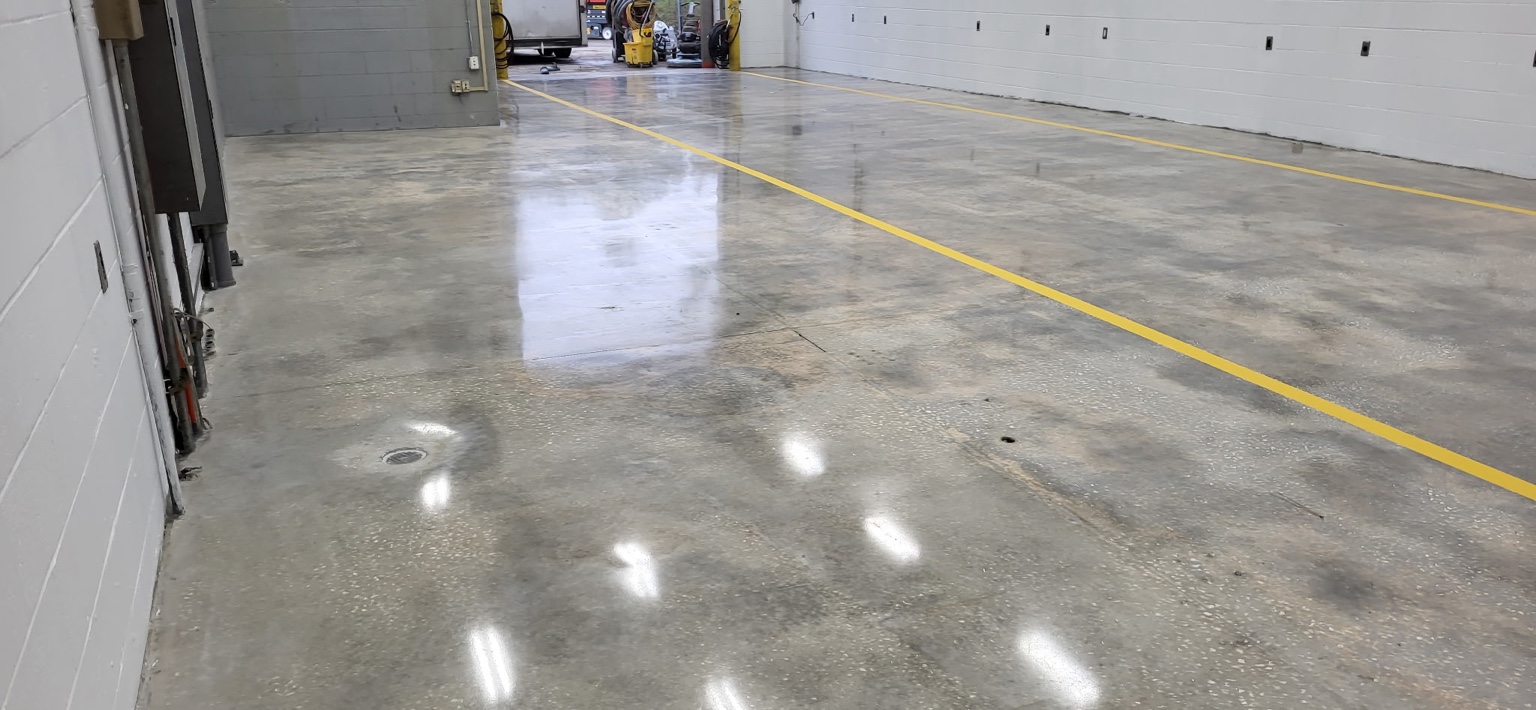 Polished concrete floor with yellow lane markings in a commercial workshop